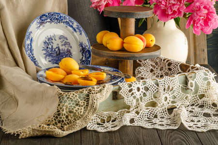 Breakfast with croissants, leaves, flowers composition with retro plates on wooden backgroundの写真素材