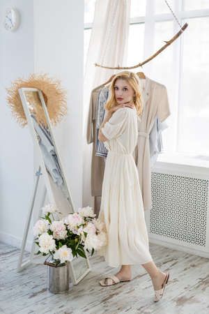 Woman shopping choosing dresses looking in mirror uncertainの写真素材