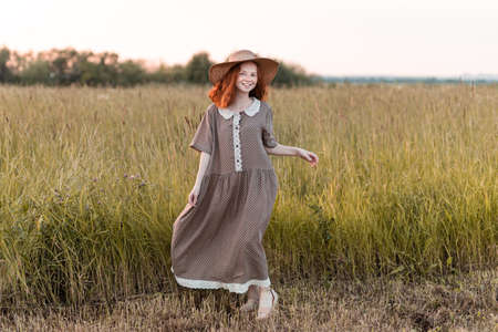redhead model posing in a meadow at sunsetの写真素材