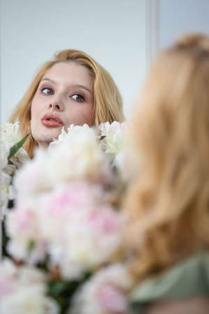 beautiful sensual girl with long blonde hair in dress with a bouquet of pink peonies flowers. Ð¡oncept of feminityの写真素材