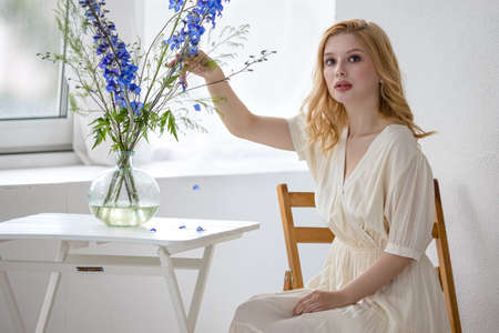 Young girl and a table with flowersの写真素材