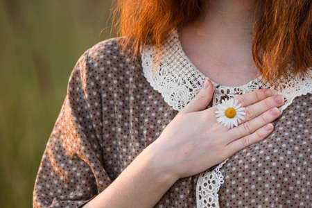 close-up, hands of a girl who plays in the grass on a summer meadowの写真素材
