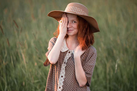 redhead model posing in a meadow at sunsetの写真素材