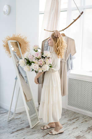 Woman shopping choosing dresses looking in mirror uncertainの写真素材