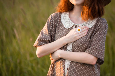 close-up, hands of a girl who plays in the grass on a summer meadowの写真素材