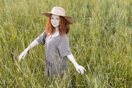redhead model posing in a meadow at sunsetの写真素材