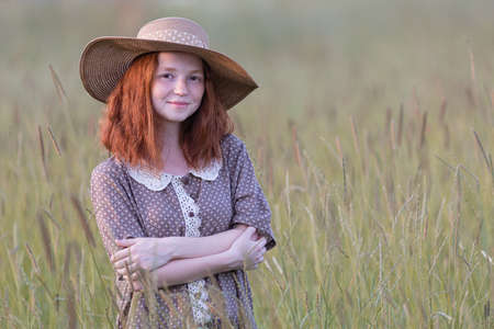 redhead model posing in a meadow at sunsetの写真素材