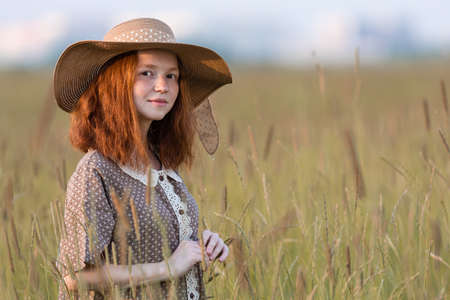 redhead model posing in a meadow at sunsetの写真素材