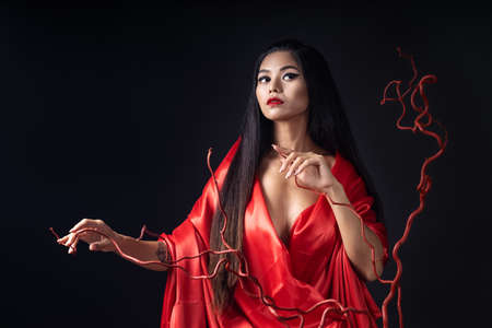 beautyful girl dressed as a geisha in a red kimono with a fanの写真素材