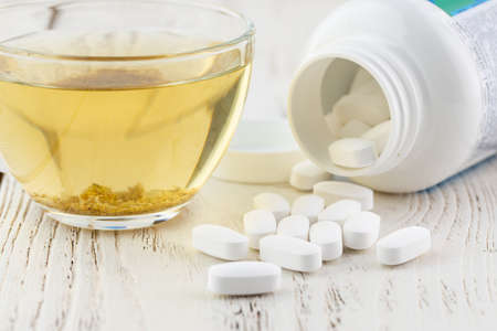 White empty medical jar, scattered tablets in capsulesの写真素材