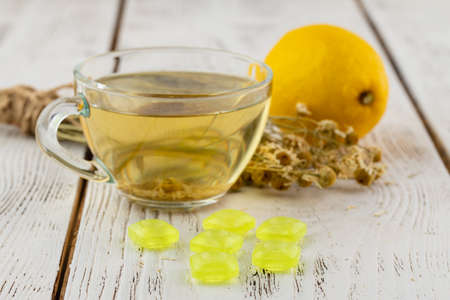 Transparent glass cup with herbal camomile tea on table with jar of honeyの写真素材