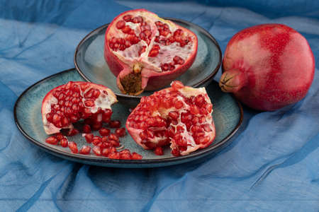 ripe pomegranate on a table on a blue backgroundの写真素材