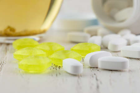 White empty medical jar, scattered tablets in capsulesの写真素材