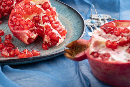 Fresh juicy ripe pomegranate on a wooden background, close-up. Pomegranate fruit, cut in halfの写真素材