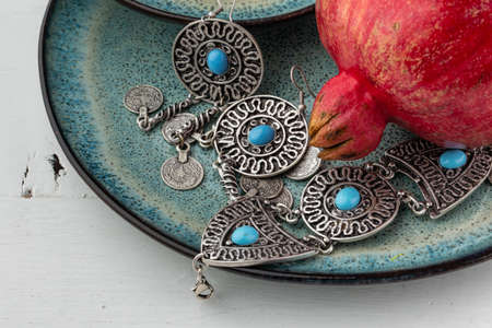 Turkish pomegranate fruit with turkish jewelery and open pomegranate, side viewの写真素材