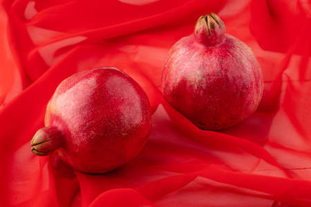 pomegranate fruit with turkish jewelery and open pomegranate on an red, side viewの写真素材