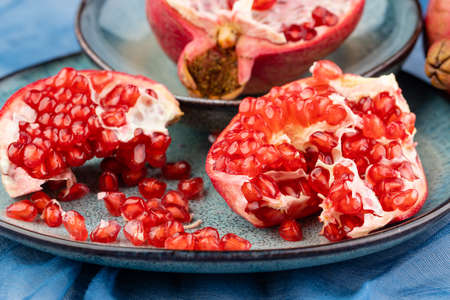 Fresh juicy ripe pomegranate on a wooden background, close-up. Pomegranate fruit, cut in halfの写真素材