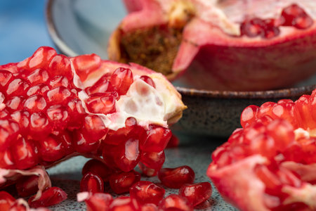 ripe pomegranate on a table on a blue backgroundの写真素材