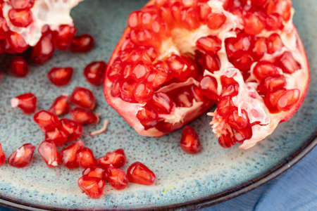 ripe pomegranate on a table on a blue backgroundの写真素材