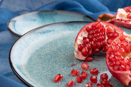 ripe pomegranate on a table on a blue backgroundの写真素材