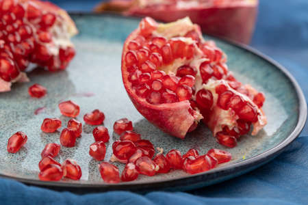 ripe pomegranate on a table on a blue backgroundの写真素材