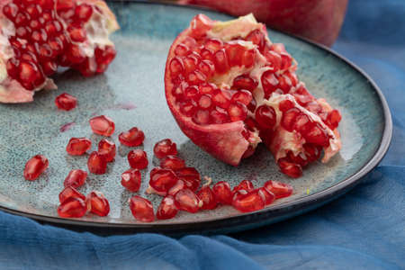 Fresh juicy ripe pomegranate on a wooden background, close-up. Pomegranate fruit, cut in halfの写真素材