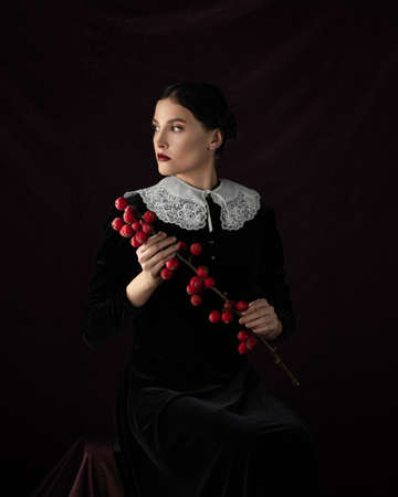 Portrait beautiful gothic woman concept. medieval clothes dress. Makeup red lips. Dark mood backgroundの写真素材