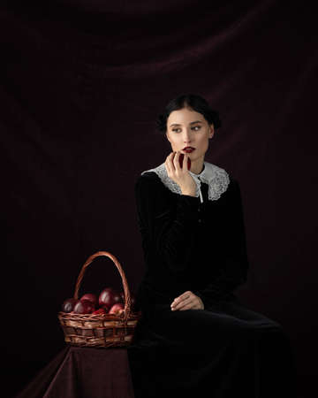Portrait beautiful gothic woman concept. medieval clothes dress. Makeup red lips. Dark mood backgroundの写真素材