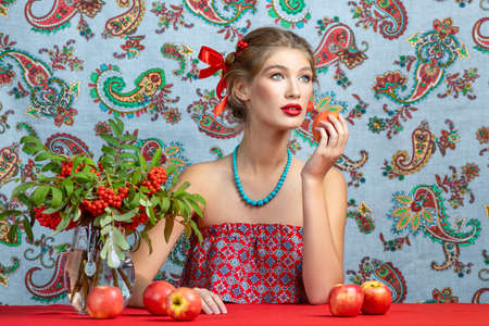 Portrait of a young model in the studio with bright autumn branches of rowanの写真素材