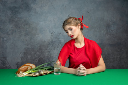 young girl at the table with bread and green onions. Very bright footageの写真素材