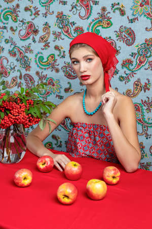 young girl in the studio with bright autumn branches of rowan and applesの写真素材