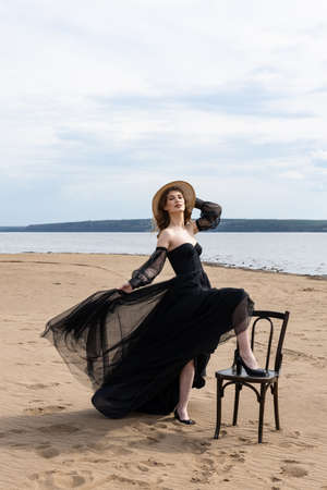 young girl in a black dress by the riverの写真素材