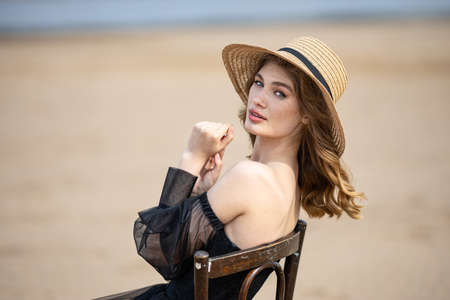 Happy young girl in black dress on the river bankの写真素材