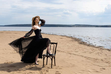 young girl in a black dress by the riverの写真素材