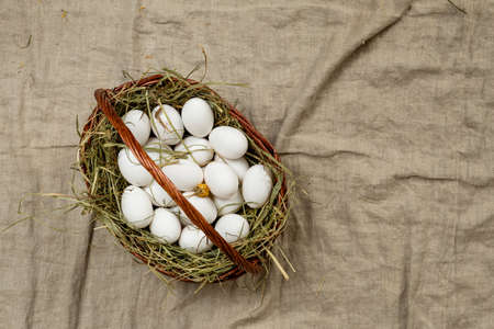 basket with chicken eggs on wooden backgroundの写真素材