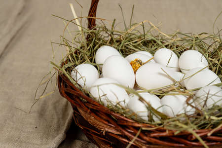 basket with chicken eggs on wooden backgroundの写真素材