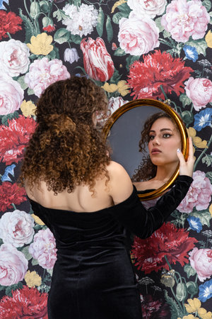 Portrait of young charming woman with flowers backgroundの写真素材