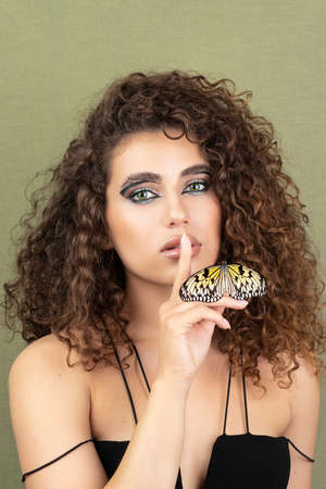 Beauty model girl posing, fashion make up with butterfly. Art design colorful make up with golden butterfliesの写真素材