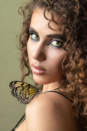 Butterfly on the girl face, green backgroundの写真素材