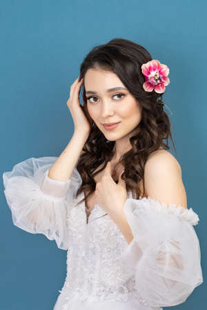 Beautiful young girl holding pink flower buds in her hands.の写真素材