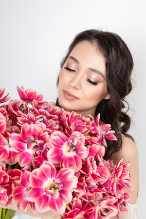Girl with a bouquet of pink tulips. Girl with a gift of flowersの写真素材