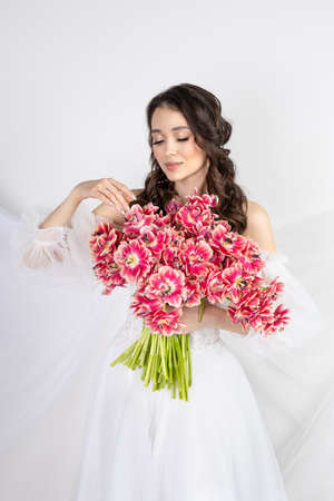 Girl with a bouquet of pink tulips. Girl with a gift of flowersの写真素材