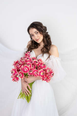 Girl with a bouquet of pink tulips. Girl with a gift of flowersの写真素材