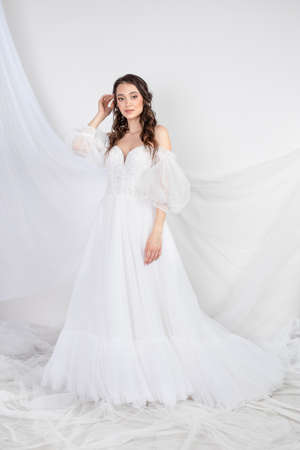 Beautiful sexy woman brunette in fashion long dress for party wedding. Bride natural model with natural makeup style for celebrity white backgroundの写真素材