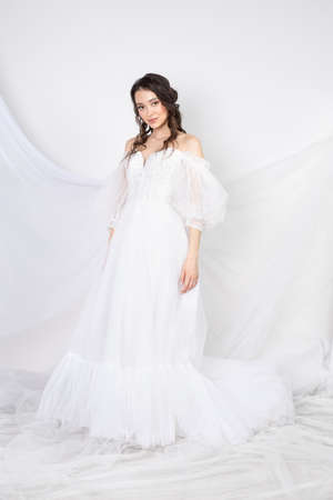 Beautiful sexy woman brunette in fashion long dress for party wedding. Bride natural model with natural makeup style for celebrity white backgroundの写真素材