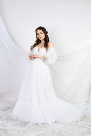 Beautiful sexy woman brunette in fashion long dress for party wedding. Bride natural model with natural makeup style for celebrity white backgroundの写真素材