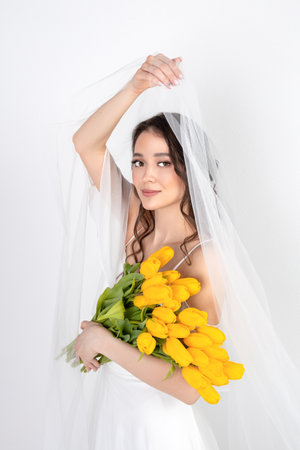 Sexy woman with flowers tulips in hands on a white backgroundの写真素材