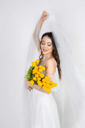cute woman with bouquet of yellow tulipsの写真素材