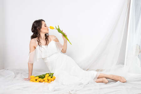 cute woman with bouquet of yellow tulipsの写真素材