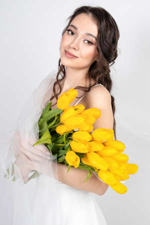 cute woman with bouquet of yellow tulipsの写真素材
